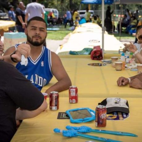 group of people smiling together for photo on a sunny day at a table