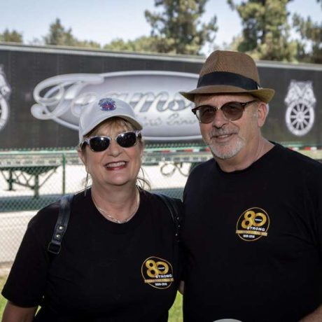 two people smiling together for photo on a sunny day in front of teamsters truck
