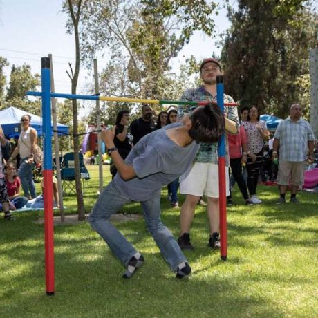 kid bending under limbo pole at park for limbo contest