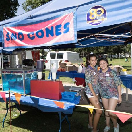 people smiling for photo at sno cones booth