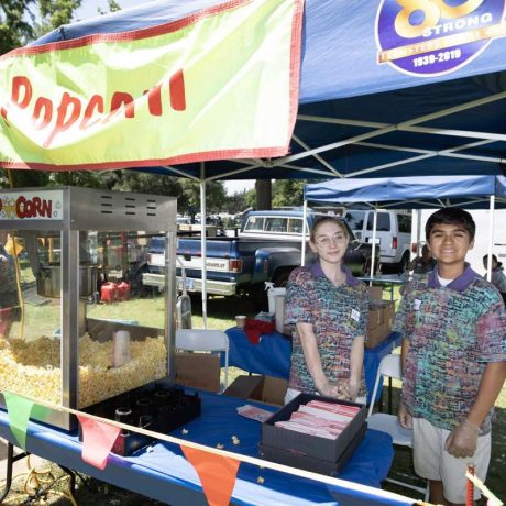 people smiling working at popcorn booth