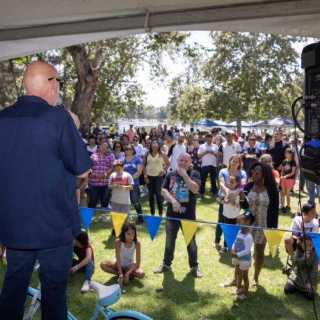 man speaking to crowd over speakers