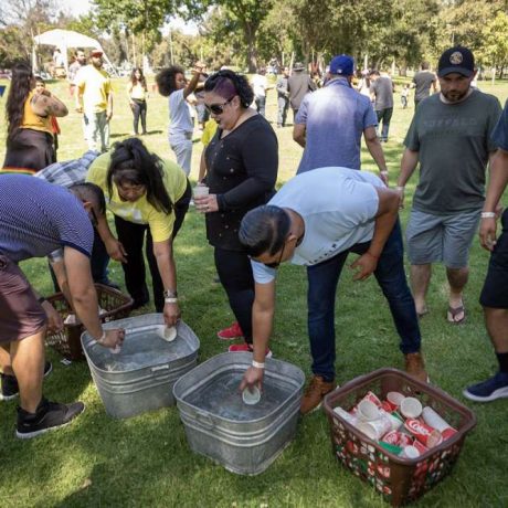 people filling cups with water