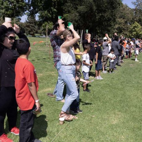 people lined up with cups of water on their heads for balance race