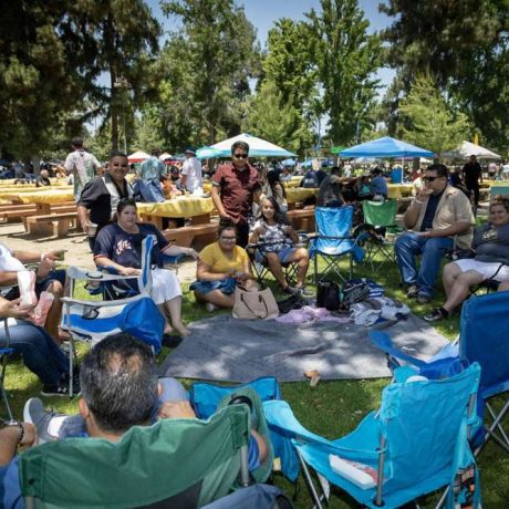 group of people sitting together at park smiling for photo