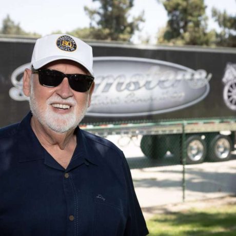 man smiling in front of teamsters bus on sunny day