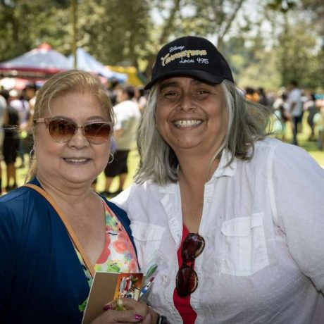 two people smiling together for photo on a sunny day