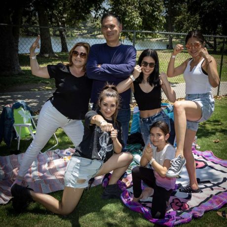 people posing and smiling together at park for photo