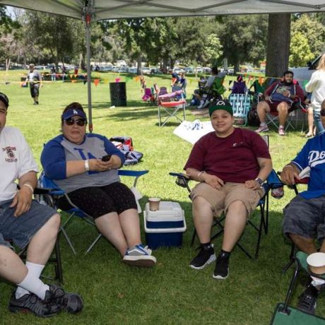 group of people smiling together for photo on a sunny day in a shaded area