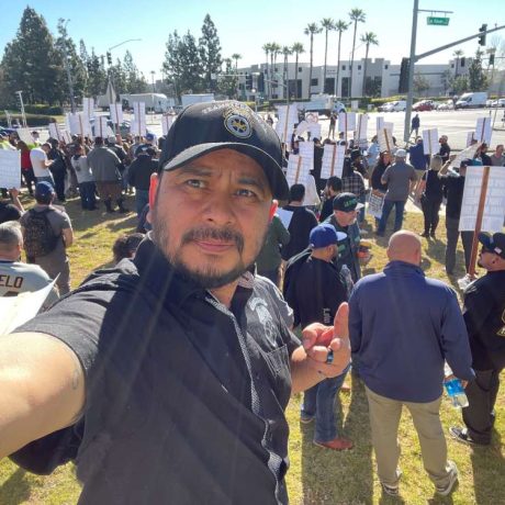 man taking selfie with large teamster rally behind him