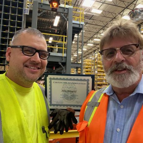 man smiling recieving certificate of completion
