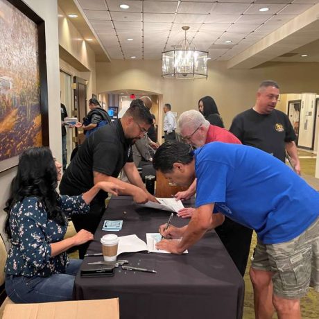 people signing documents at seminar