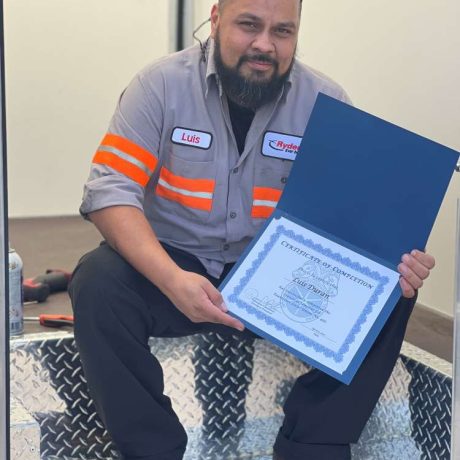 man smiling holding certificate of completion