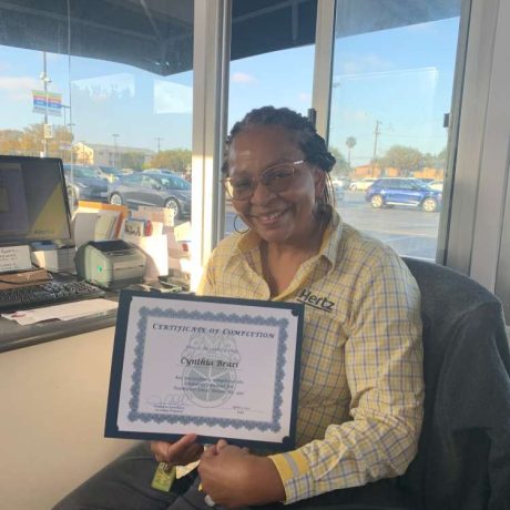 woman smiling holding certificate of completion