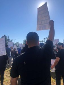 people holding up signage at rally