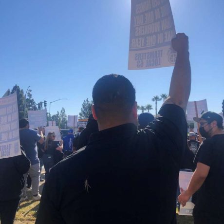 people holding up signage at rally