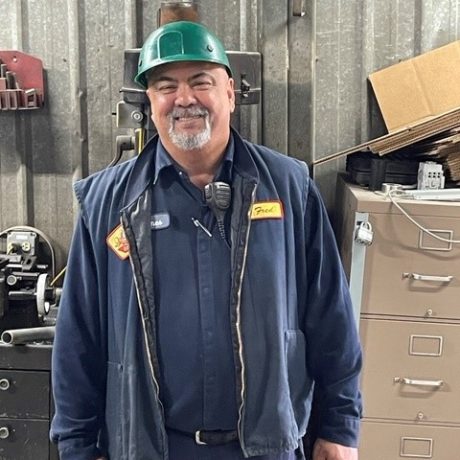 man smiling in work clothing and hard hat