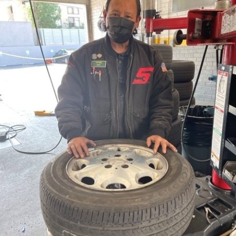 man standing in garage working on wheel