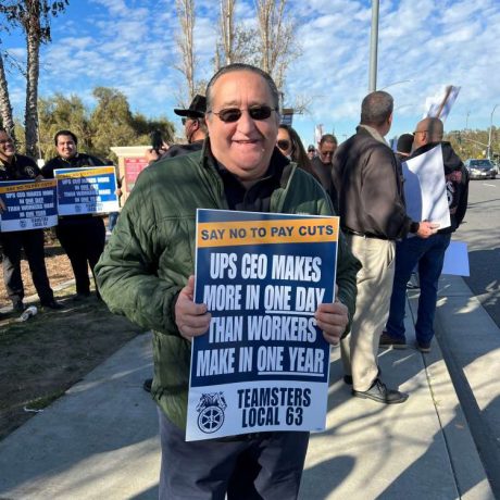 smiling man posing for photo holding teamster sign