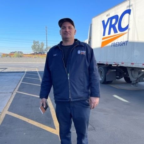 man standing for photo in front of truck