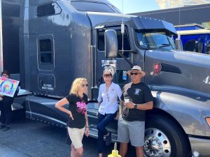 people posing and smiling together next to teamsters truck