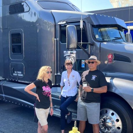 people posing and smiling together next to teamsters truck