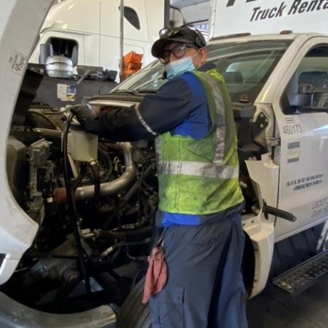 man working on truck in uniform