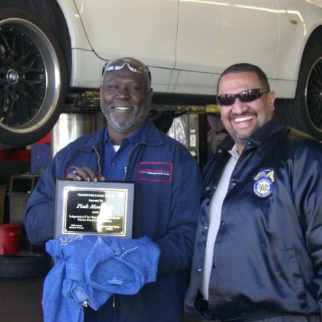 gene revera smiling with man holding plaque