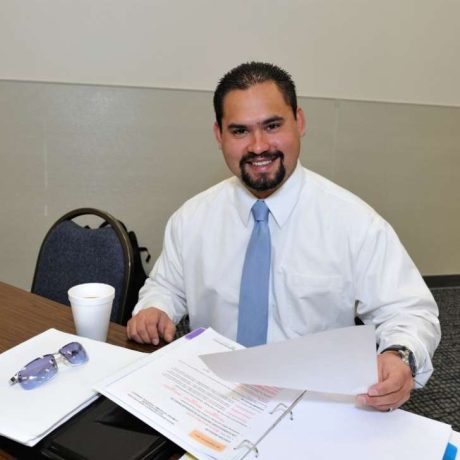 smiling man holding documents