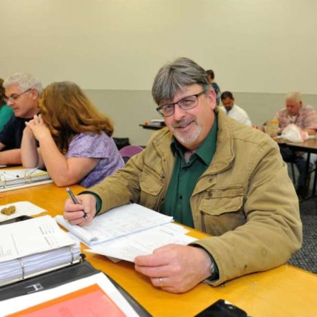 man smiling and reviewing notes
