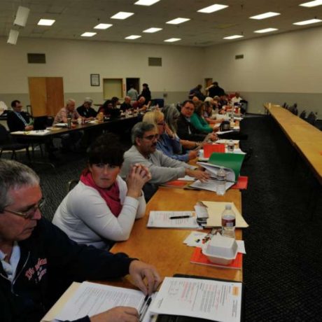 people seated in room with folders and papers