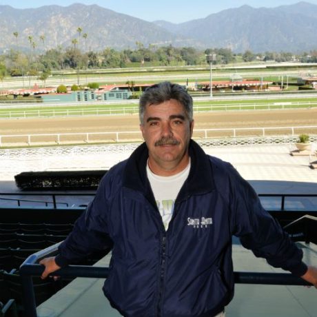 man standing with racetrack behind him