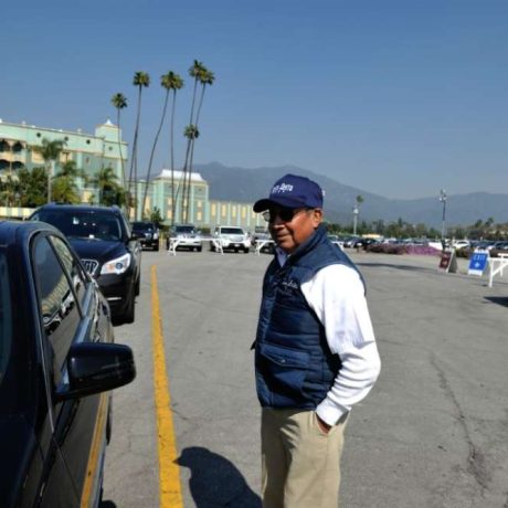 man smiling next to car