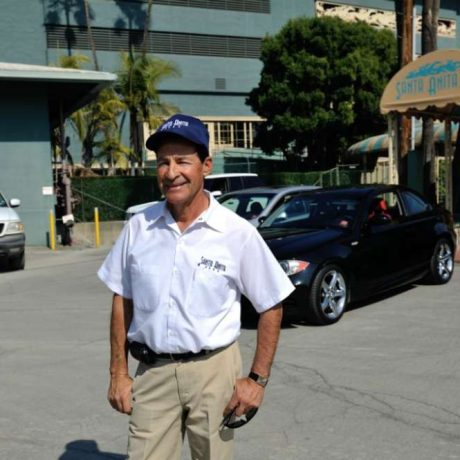 man smiling in front of park