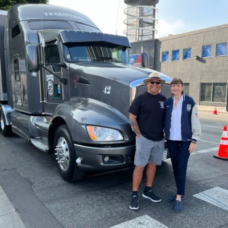 people standing in front of big rig smiling