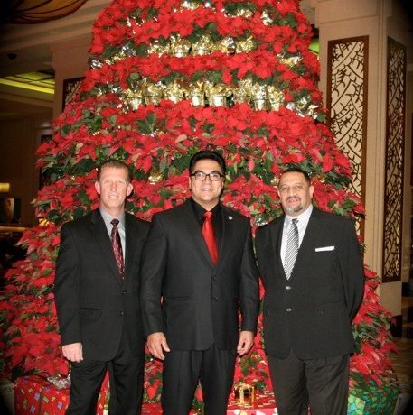 men smiling together in front of christmas tree
