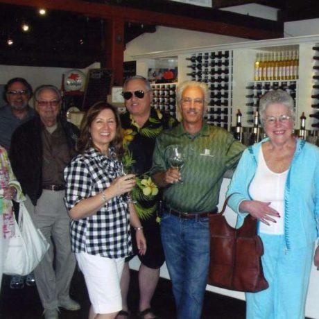 group of people smiling for photo in front of winery bar