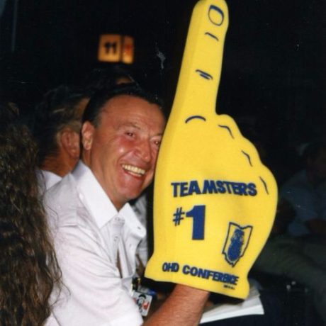 karl ullman smiling with giant foam finger with teamster information printed on it