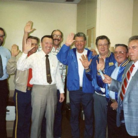 group of men standing together waving to camera