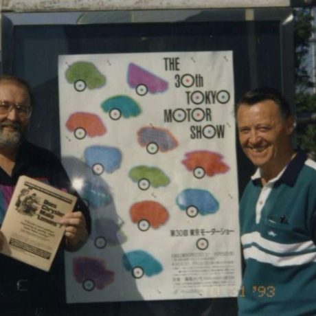 men smiling together at motor show