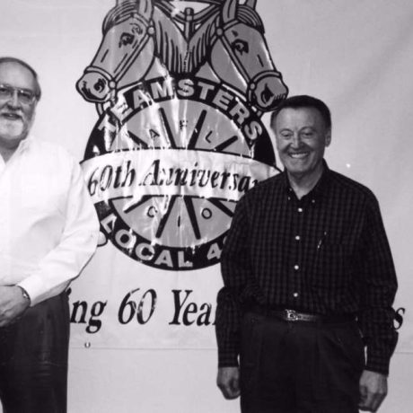 men smiling in front of teamsters 60th anniversary image