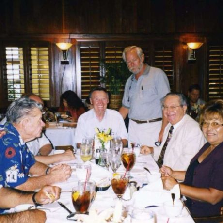 long table in restaurant with people seated smiling at camera