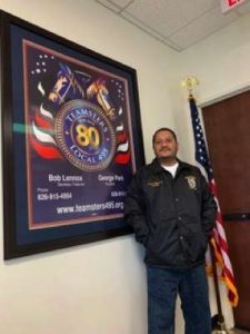 brother pail standing with teamster poster and flag